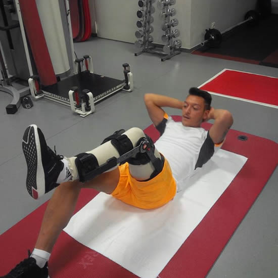 Arsenal playmaker Mesut Ozil posts an injury update picture of him wearing a knee brace