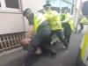 The man was dragged behind a police car by officers before being restrained on the ground Credit: Youtube / Lowry Hotel, Manchester 